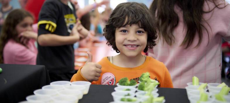 Young child smiling with veggies