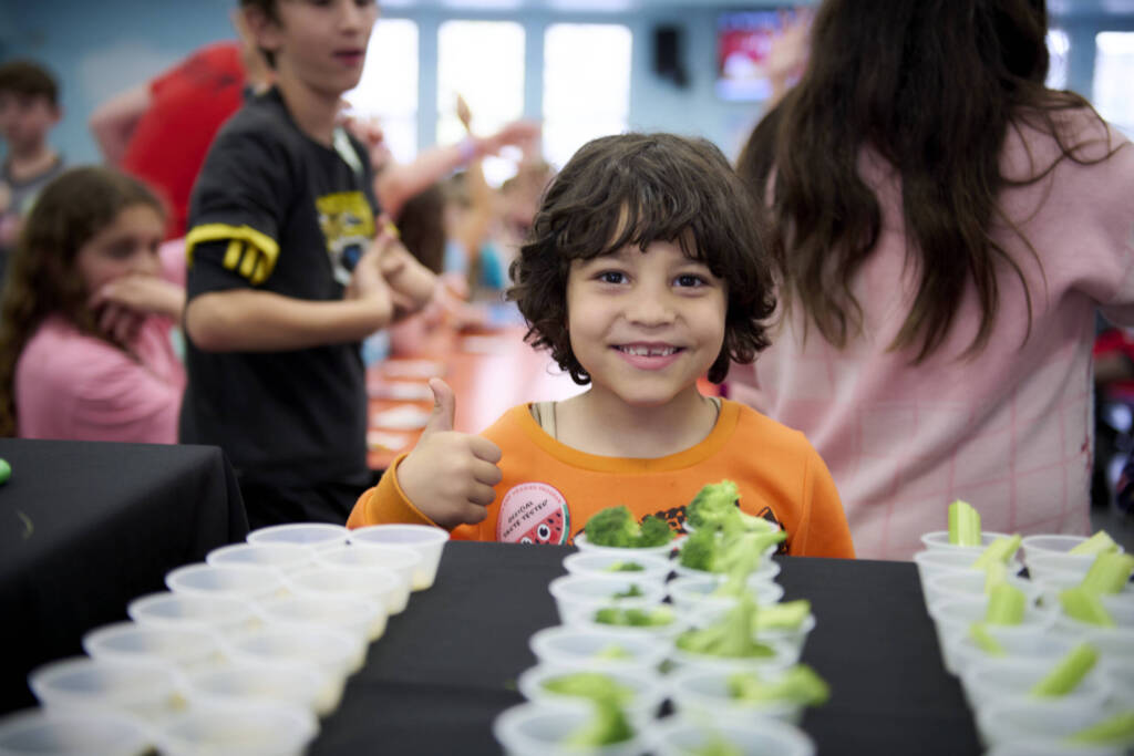 Young child smiling with veggies